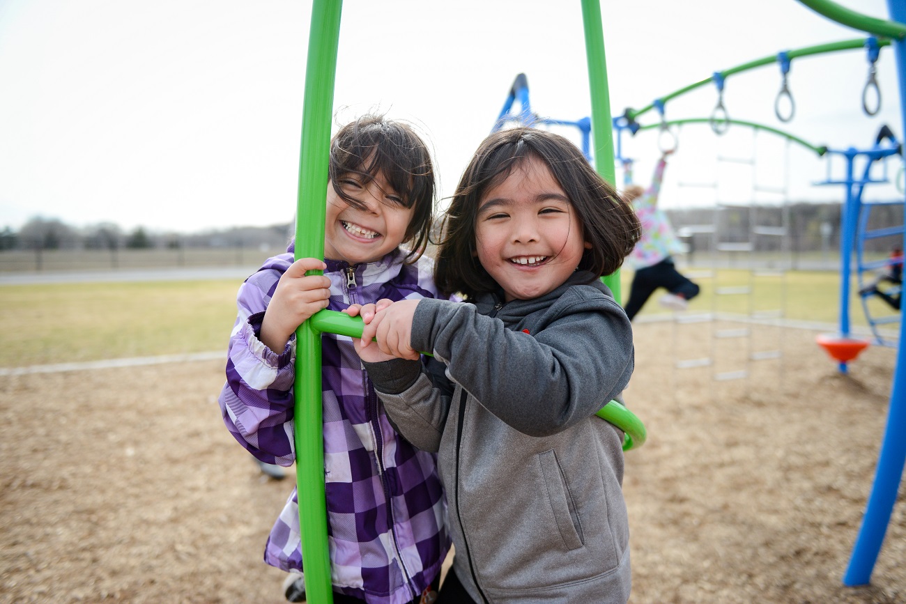 Two students play together on a playground swing during recess at Leadership Academy of Arizona, highlighting the importance of movement, social interaction, and student well-being as part of a supportive academic environment.