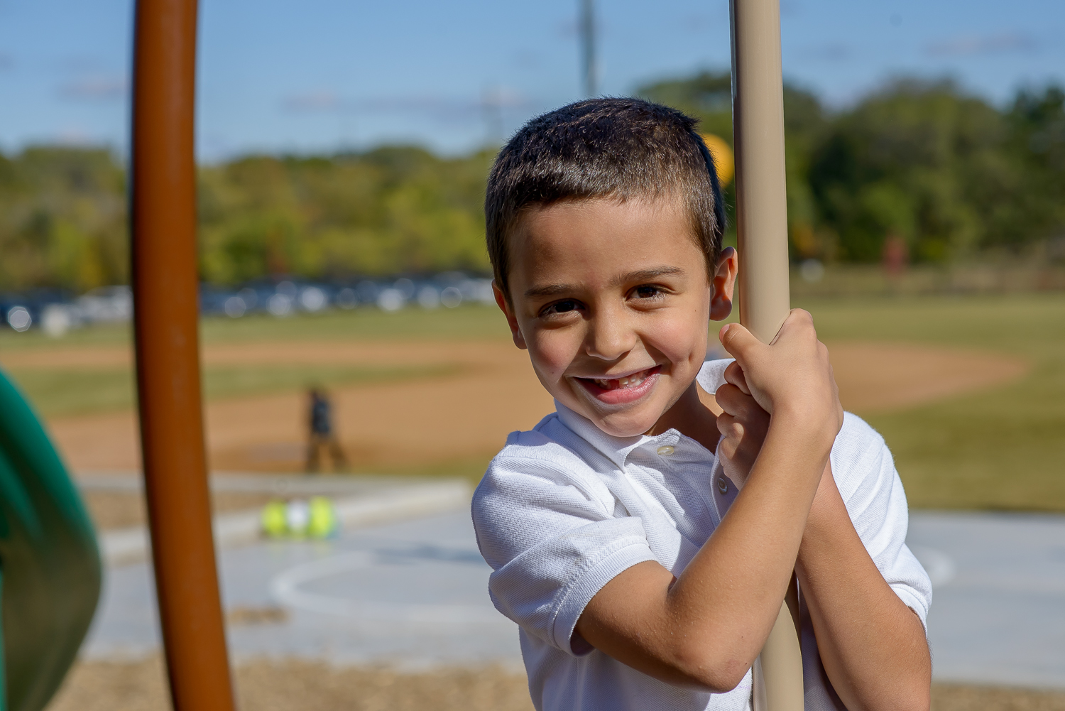 Enrichment & Student Life student enjoying outdoor recess on a playground swing.