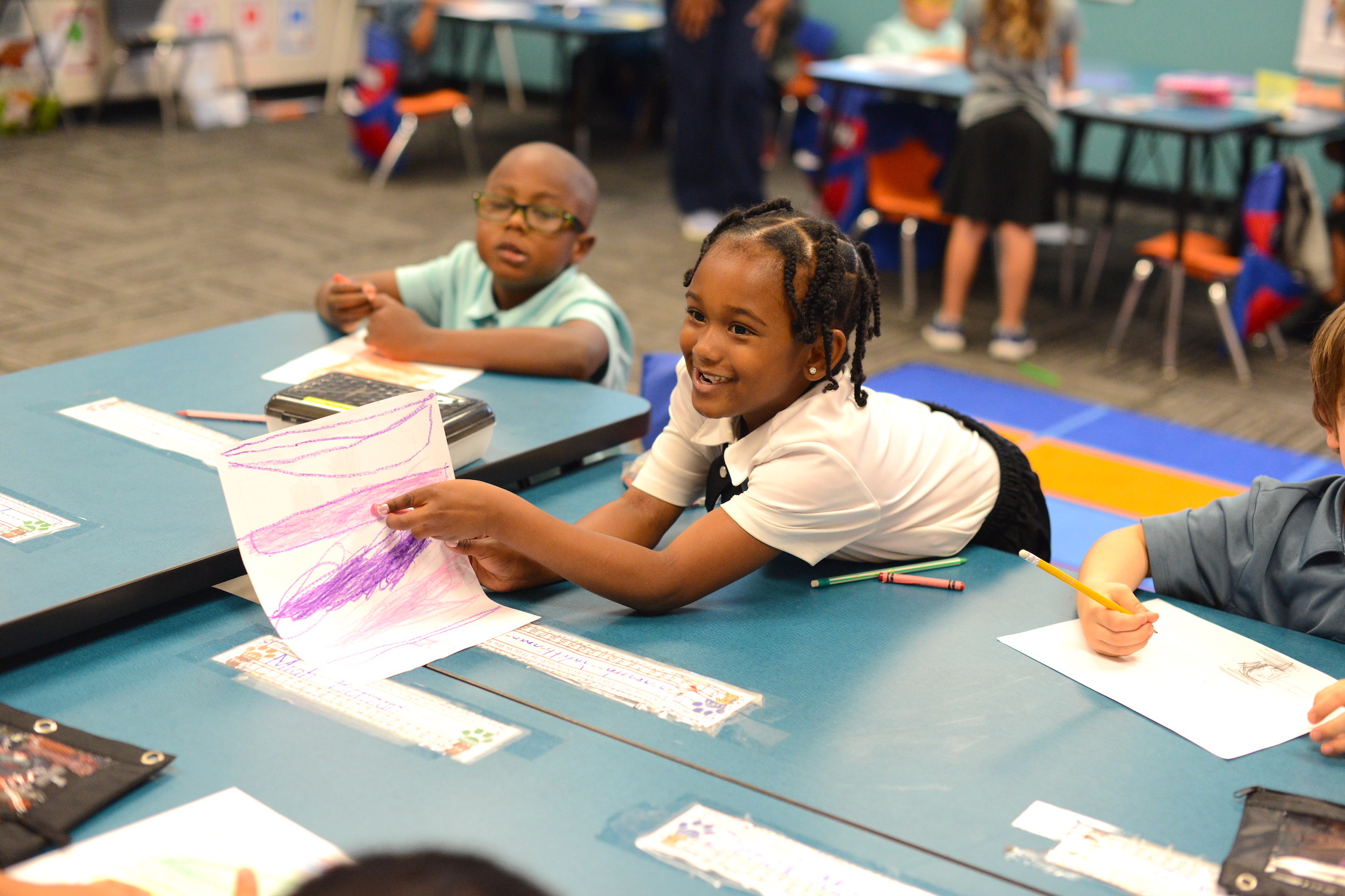 Student boy working at his desk during Opening Ceremony demonstrating focus, responsibility, and readiness to learn.